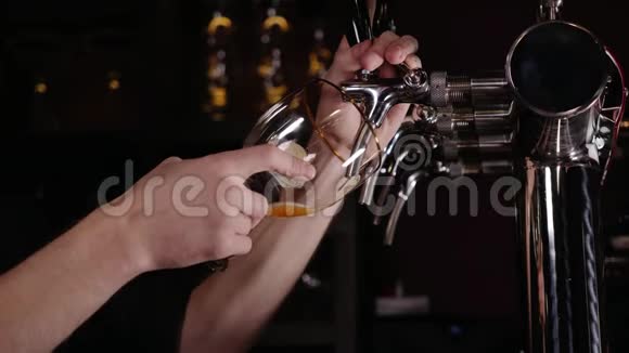 酒保在餐馆或酒吧的水龙头里倒一大杯啤酒的手视频的预览图