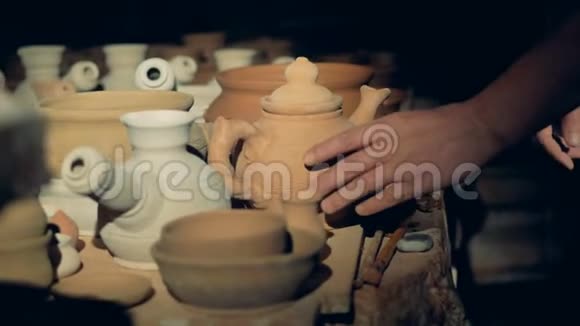 一个陶器工人检查陶罐摸着它的嘴唇视频的预览图