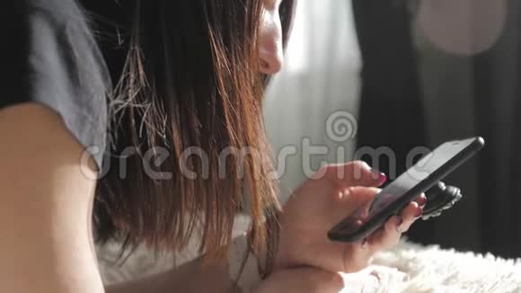 年轻女子坐在床上用智能手机做网上购物网上购物的概念视频的预览图