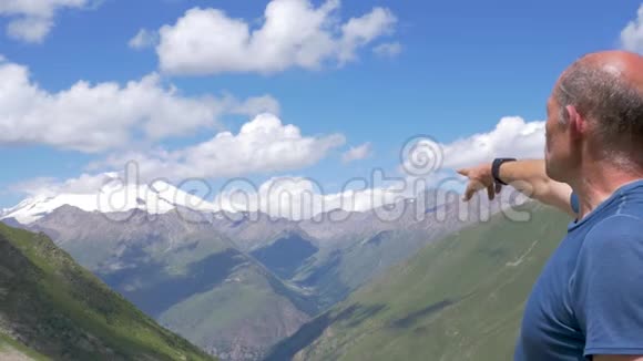 一位旅行者站在高山上看着埃尔布鲁斯的山顶视频的预览图