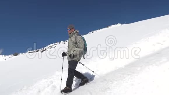 一个登山者沿着积雪覆盖的斜坡向下到达大本营埃尔布鲁斯山高加索山脉视频的预览图