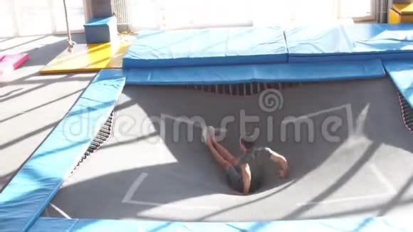年轻的运动员在飞行公园的蹦床上跳跃和飞行视频的预览图