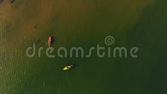 两艘皮艇从上面沿着海景行驶运动皮艇秋日在平静的湖面上划独木舟游客视频的预览图