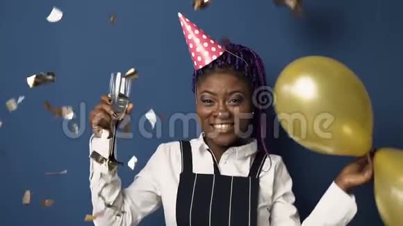 年轻的非洲女人一只手拿着香槟杯另一只手拿着气球跳舞视频的预览图