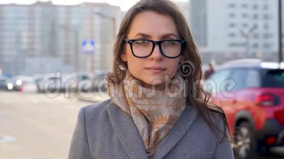 在城市背景特写中戴着发型和中性化妆眼镜的女人的肖像视频的预览图