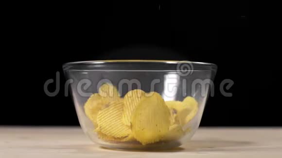 慢动作视频摔碎的土豆片到玻璃碗里摸索炸土豆啤酒小吃不健康视频的预览图