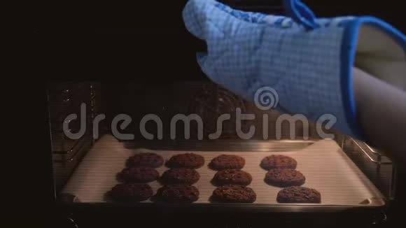 厨师的手从烤箱里拿出一盘准备好的燕麦饼干视频的预览图