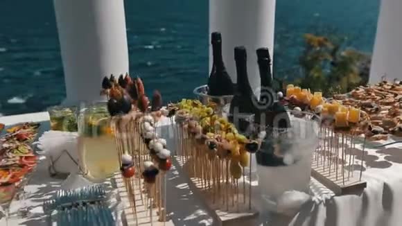接待桌上有装满新鲜沙拉的酒杯室外靠近大海的餐桌全景视频的预览图