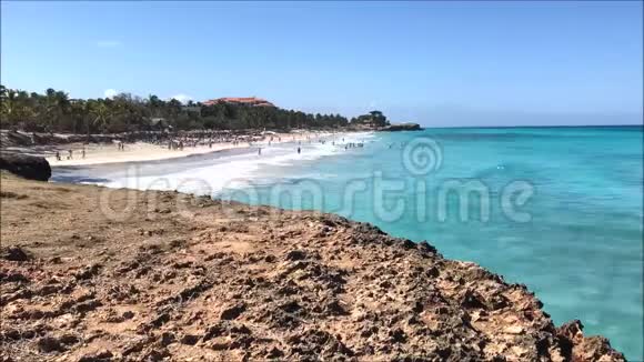 加勒比海阳光明媚的一天热带沙滩和岩石海岸的延时录像片段视频的预览图