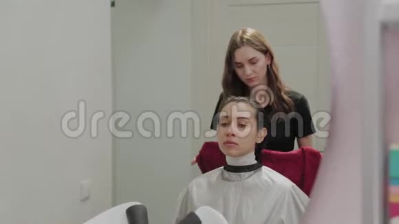 美容美发沙龙一个理发师正在用毛巾把客户的头发洗了之后在水槽里擦拭视频的预览图