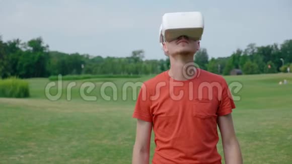 一个男人在公园里用一个虚拟现实耳机把头仰起来视频的预览图