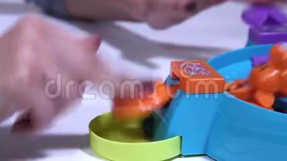 雌性的手在用彩色球喂养饥饿的塑料青蛙视频的预览图