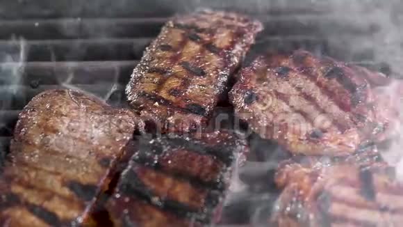 果汁肉牛排在烤架上肉被烧了有一股烟相机从左到右移动美味的牛肉视频的预览图