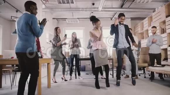 两位非裔美国人在办公室成功庆祝晚会慢动作上展示有趣的民族舞蹈动作视频的预览图