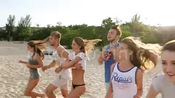 一群朋友在日落时脱掉衣服跑到海水里在海滩上扔衬衫快乐快乐的人视频的预览图