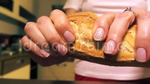 年轻的女人在吃新鲜的法国面包视频的预览图