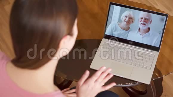出国留学的女儿通过messenger应用程序在笔记本电脑上与父母视频聊天视频的预览图