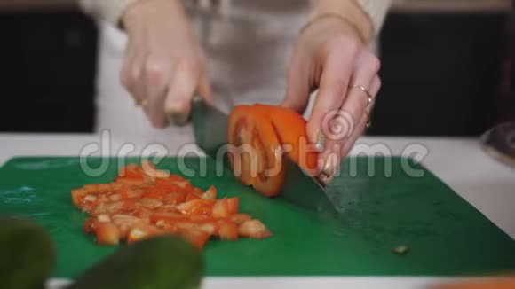 一个女孩正在厨房里做沙拉她把红色多汁的西红柿切成许多小块视频的预览图