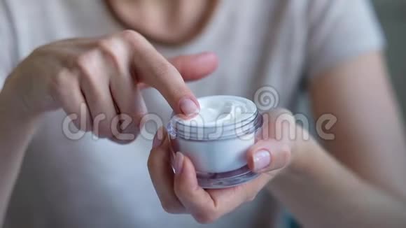 面部皮肤护理特写女性双手涂抹奶油乳液美容和身体护理概念视频的预览图