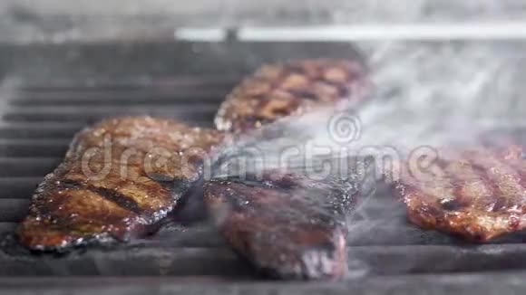 酋长用钳子把肉放在烤架上多汁的脂肪炸肉牛肉在大火中炸了很多火灾和烟雾视频的预览图