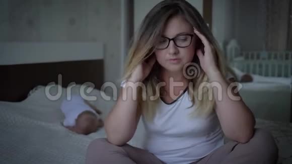 戴眼镜的妇女患头痛病在家睡觉时的背景视频的预览图
