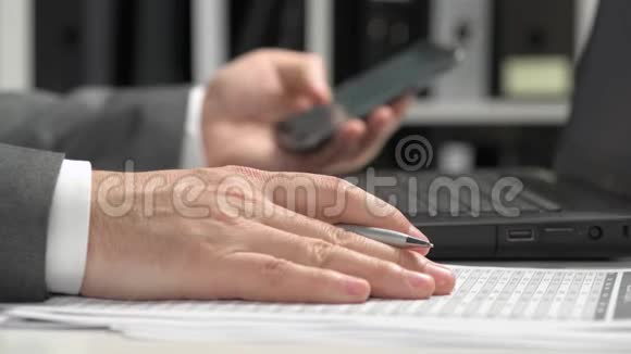 商人在办公室工作使用智能手机和笔记本电脑企业财务会计理念视频的预览图