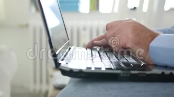 坐在办公室椅子上的人用手提电脑捏他的膝盖视频的预览图