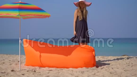热带海滩上的年轻女子躺在充气沙发上暑假概念视频的预览图