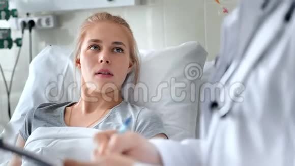 男医生在病床上与女病人交谈带剪贴板和x光照片的微笑医生视频的预览图