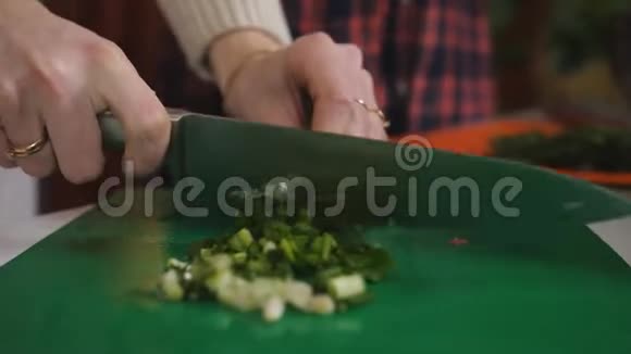厨房里的女孩正在切葱做沙拉两个女孩正在厨房准备蔬菜沙拉视频的预览图