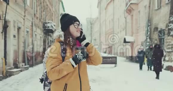 女人在冬天的街道上用手机说话背景是建筑物视频的预览图