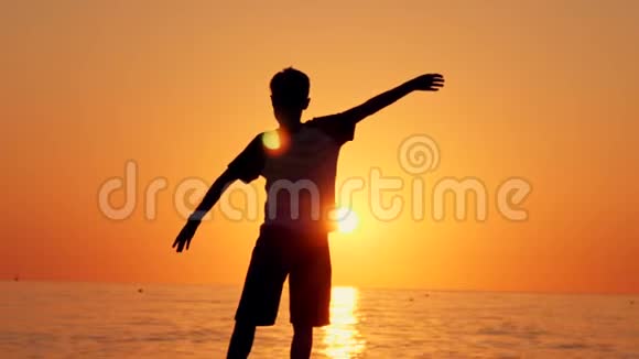一个男孩站在海滩上的剪影幸福的概念梦想人类的空间孩子们梦想视频的预览图