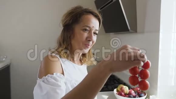 年轻的女人和穿着白色衣服的女孩吃着美味的红西红柿在视频的预览图