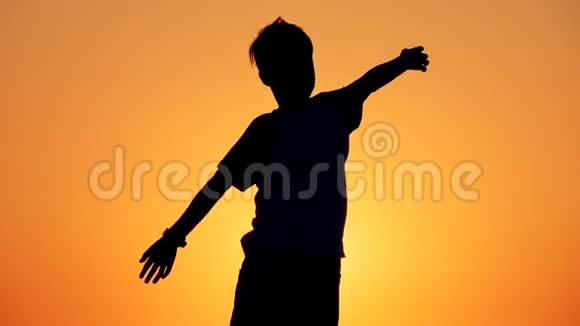 一个男孩站在海滩上的剪影幸福的概念梦想人类的空间孩子们梦想视频的预览图