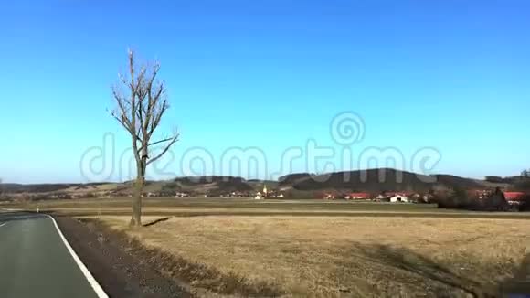 对两台风力涡轮机和小镇的视野在初春从波兰的汽车上看视频的预览图
