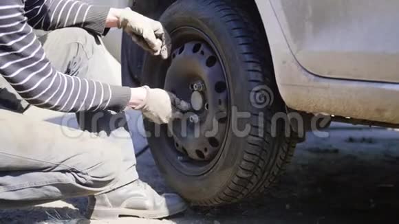 阳光明媚的一天男车技师在街上更换汽车车轮轮胎视频的预览图