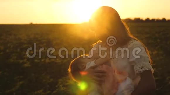 日落时分妈妈带着小孩在夏日公园散步孩子在妈妈的手睡着了慢镜头拍摄视频的预览图