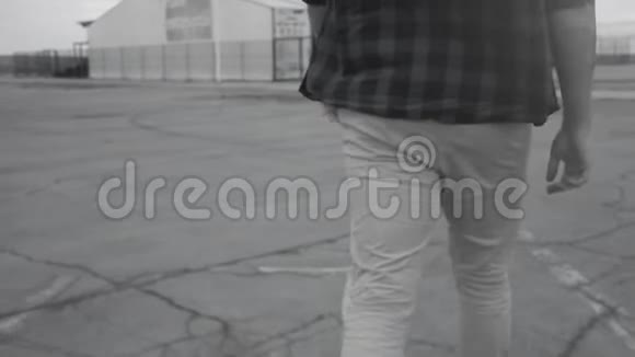 一个穿着格子衬衫和牛仔裤走路的人的后视图以史诗般的方式行走自信地行走从视频的预览图