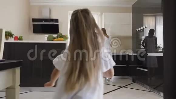 小女孩很高兴再次在厨房里和她的母亲和姐姐在家里见面姐姐为她做早餐视频的预览图