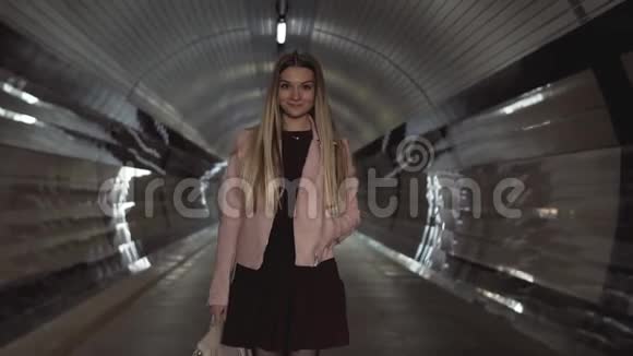 夕阳下穿着粉色夹克的迷人少女穿过隧道视频的预览图