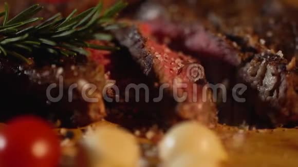 盐洒在美味的烤肉片上放在红色西红柿和洋葱旁边的切肉板特写镜头视频的预览图