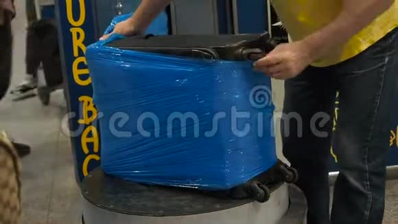 机场行李包装服务行李用玻璃纸保鲜膜包装工人包裹了大量视频的预览图