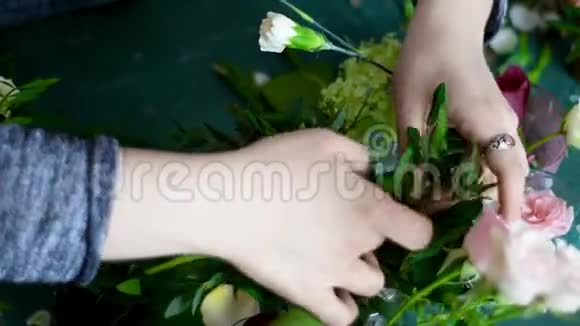 花商从花瓶里挑一枝绿叶作花束视频的预览图