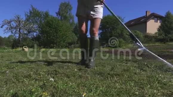 在草地上用耙子干活的女人视频的预览图