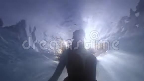 穿着长裙的女人在水下游泳阳光透过水面4K视频的预览图