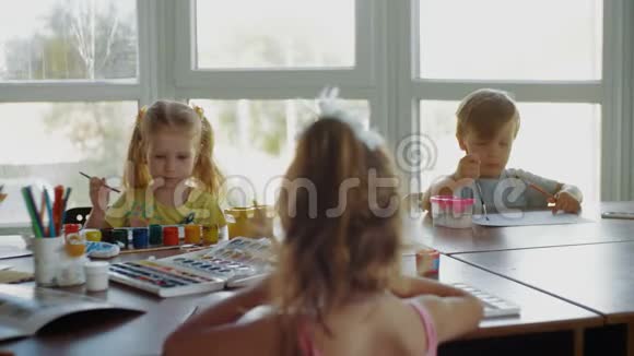 两个女孩和男孩的学生在一所学校素描和画画视频的预览图