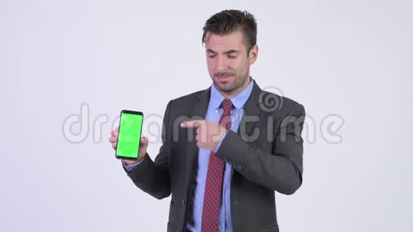 年轻快乐的西班牙商人带着电话竖起大拇指视频的预览图