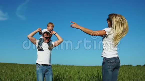 快乐的一家人在野外阳光明媚的一天在公园里玩得很开心度过时光儿子坐在他父亲视频的预览图