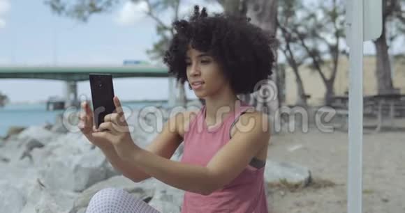 开朗的黑人女人在海边自拍视频的预览图
