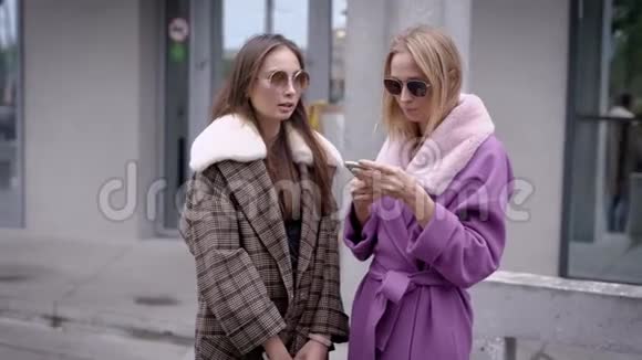 两个女人站在外面秋天看起来时尚两个朋友说话视频的预览图